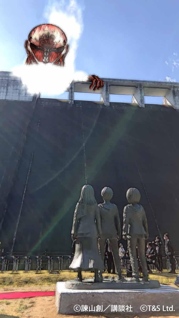 ３人の少年期の銅像の背景に大山ダムの壁面から巨人のAR