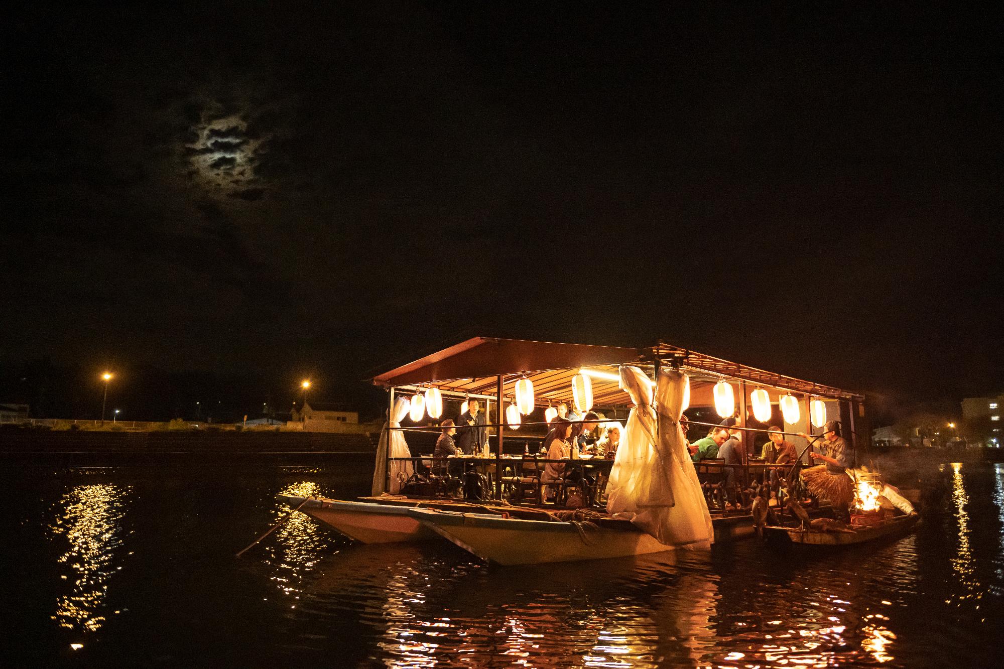 屋形船で鵜飼の説明をする鵜匠