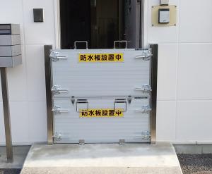 出入り口の前に着脱式止水板を設置している様子の写真