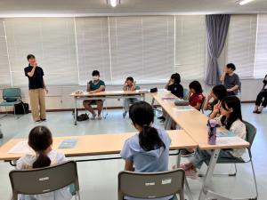 手話通訳者が手話であいさつをしている様子の写真