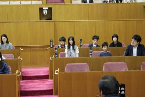 こども議会体験会でこども（4人目）が議員席で質問している様子の写真