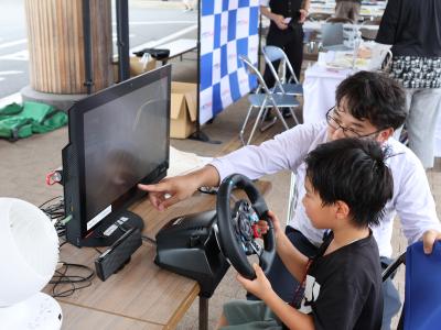 子どもがドライブシミュレーターを体験している様子の写真
